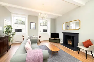 a living room with a couch and a fireplace at Stylish 1-Bedroom Edinburgh Apartment in Edinburgh