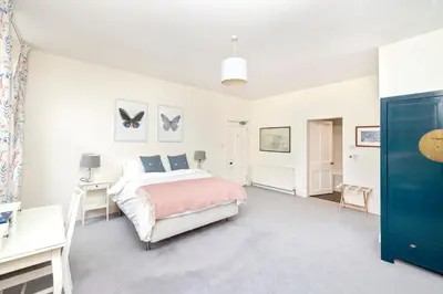a white bedroom with a bed and a desk at Charming Edinburgh Apartment with 2-Bathroom and Private Entrance in Edinburgh