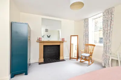 a living room with a fireplace and a chair at Charming Edinburgh Apartment with 2-Bathroom and Private Entrance in Edinburgh