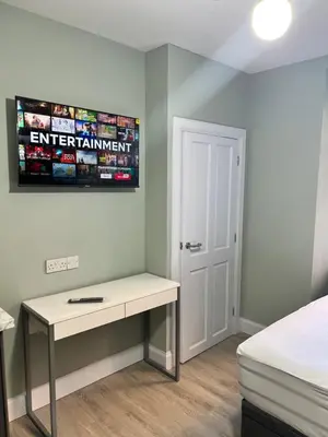 a bedroom with a desk and a sign on the wall at The Dixon - Commonwealth Games 2026 in Glasgow
