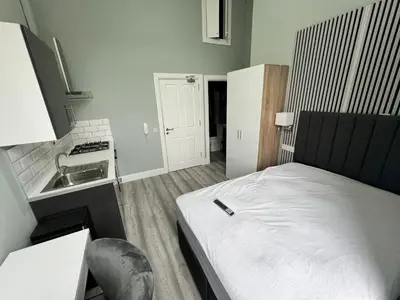 a small kitchen with a bed and a sink at The Dixon - Commonwealth Games 2026 in Glasgow