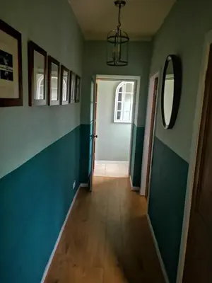 a hallway with green walls and a door at Cosy cottage near Thornhill in Closeburn
