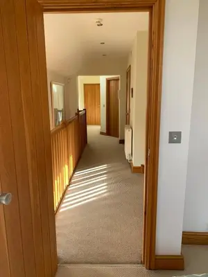 a hallway with a hallway leading into a room with wooden doors at Tan Y Bedw Barn in Moffat
