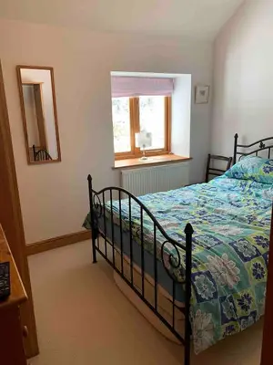 a bedroom with a bed and a window at Tan Y Bedw Barn in Moffat