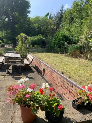 a brick wall with three potted flowers and a picnic table at Tan Y Bedw Barn in Moffat