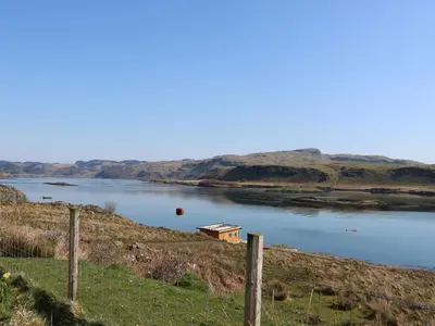 a lake with a house in the middle of it at Sula in Oban