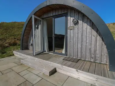 a circular building with an open door on a deck at Torsa in Oban
