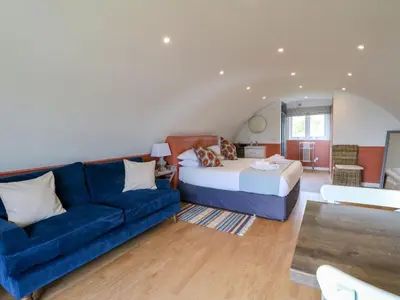 a living room with a blue couch and a bed at Fladda in Oban