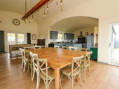 a kitchen and dining room with a wooden table and chairs at WildLuing in Oban