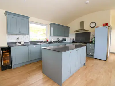 a kitchen with blue cabinets and a white refrigerator at WildLuing in Oban