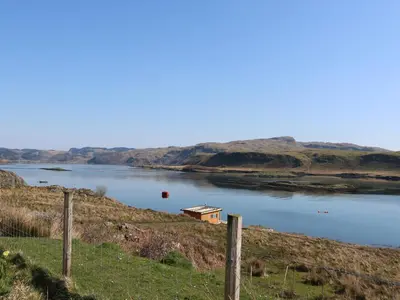 a lake with a house in the middle of it at WildLuing in Oban