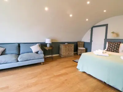 a living room with a blue couch and a bed at Creags in Oban