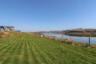 a grassy field next to a body of water at Creags in Oban
