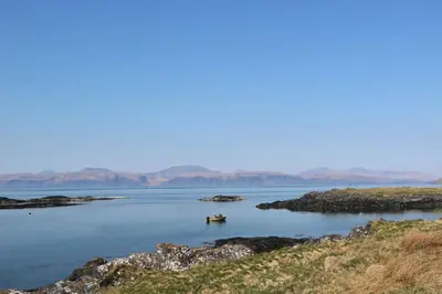 a small boat in a large body of water at Scarba in Oban