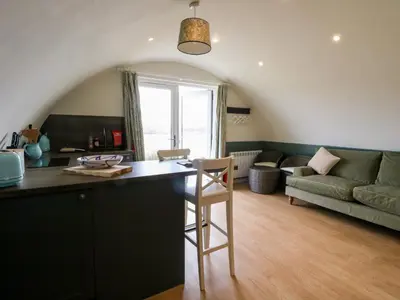 a kitchen and living room with a table and a couch at Insh in Oban