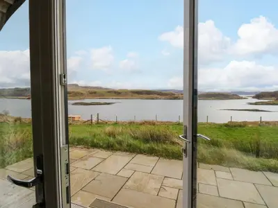 an open door with a view of a lake at Losal in Oban