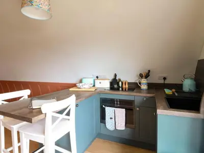 a kitchen with a counter and a table with chairs at Losal in Oban