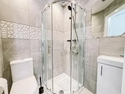 a bathroom with a shower and a toilet at Itohan 3-bed Cottage Flat in Glasgow