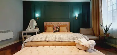 a bedroom with a large bed with a green wall at KKLM Holidays in Largs