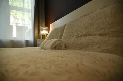 a bedroom with a bed with a blanket and a window at KKLM Holidays in Largs