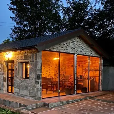 a stone cottage with sliding glass doors at The Owl Stony Snug in Carstairs Junction