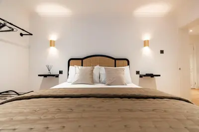 a bedroom with a large bed with white walls at Hamilton Residence - Private Main Door 1BR in Glasgow