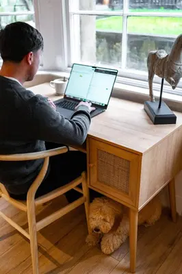 a man sitting at a desk with a laptop computer at Hamilton Residence - Private Main Door 1BR in Glasgow