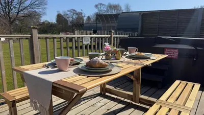 a wooden table with plates of food on it at The Tummel Lodge with Hot Tub in Crieff in Crieff