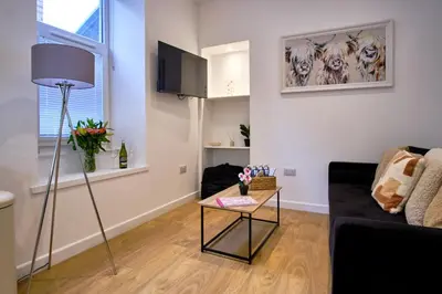 a living room with a couch and a table at 2 bedroom, newly-renovated, comfortable town centre apartment! in Oban