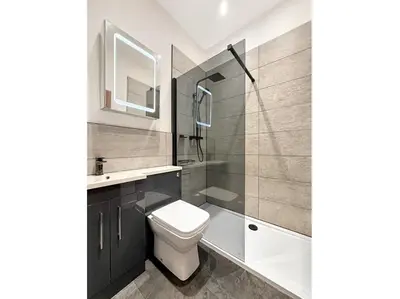 a bathroom with a toilet and a sink and a mirror at 2 bedroom, newly-renovated, comfortable town centre apartment! in Oban