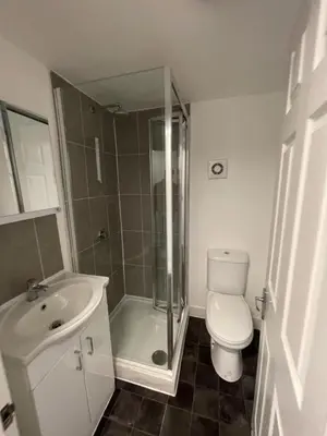 a bathroom with a shower and a toilet and a sink at London Holiday Home - 8mins walk from Station Zone 2 in Moffat