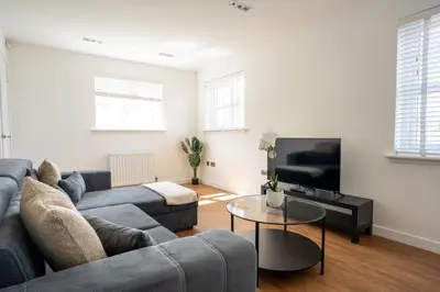 a living room with a couch and a tv at Bartonshill House in Glasgow