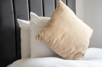 a pillow sitting on a bed with white pillows at Bartonshill House in Glasgow