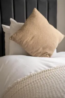 a bed with white sheets and pillows at Bartonshill House in Glasgow