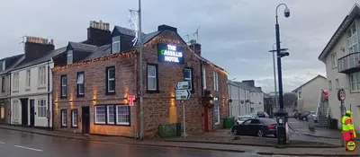 a brick building with a sign on it on a street at Hotel Room in Maybole for Work Travel & Leisure in Maybole
