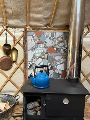 a blue tea kettle sitting on top of a stove at Magical Quirky Romantic Yurt in Balquhidder in Balquhidder
