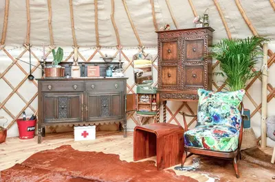 a room with a yurt with a chair and a cabinet at Magical Quirky Romantic Yurt in Balquhidder in Balquhidder