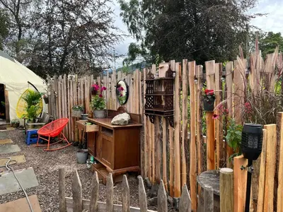 a wooden fence with a desk in a yard at Magical Quirky Romantic Yurt in Balquhidder in Balquhidder