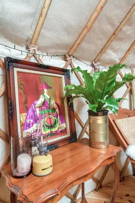 a table with a painting and a potted plant on it at Magical Quirky Romantic Yurt in Balquhidder in Balquhidder