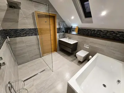 a bathroom with a tub and a toilet and a sink at Fyne Edge - A Luxurious Lochside Haven in Minard