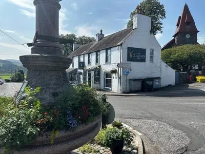 a building on the corner of a street with a flower pot at The Clachan Inn in Dalry