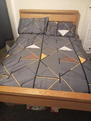 a bed with a comforter and pillows on it at Kaffuhsmartt in Drumchapel