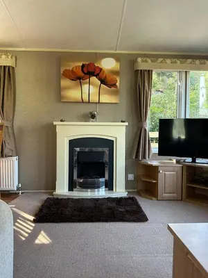 a living room with a fireplace and a television at The Grosvner 61 in Dunoon