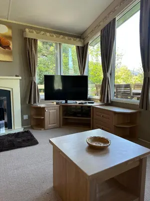 a living room with a flat screen tv and a table at The Grosvner 61 in Dunoon