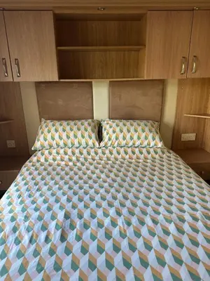 a bed in a small room with wooden cabinets at The Grosvner 61 in Dunoon