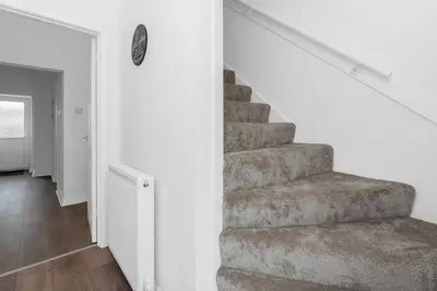 a staircase in a white room with a stair case at Appin House -Cosy 2 bed house in Dunfermline in Dunfermline