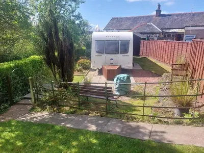 a caravan parked in a yard with a fence at Railway cottage caravan in Oban