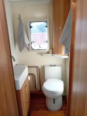 a small bathroom with a toilet and a sink at Railway cottage caravan in Oban