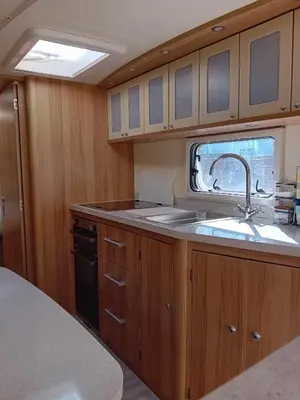 a kitchen with wooden cabinets and a sink and a window at Railway cottage caravan in Oban