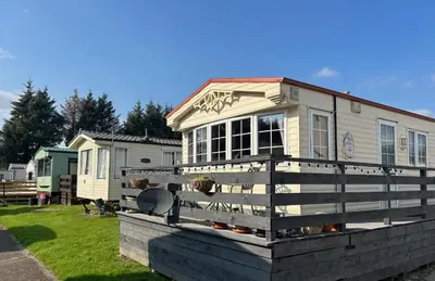 a house sitting on top of a wooden fence at Creebridge Caravan Park in Newton Stewart